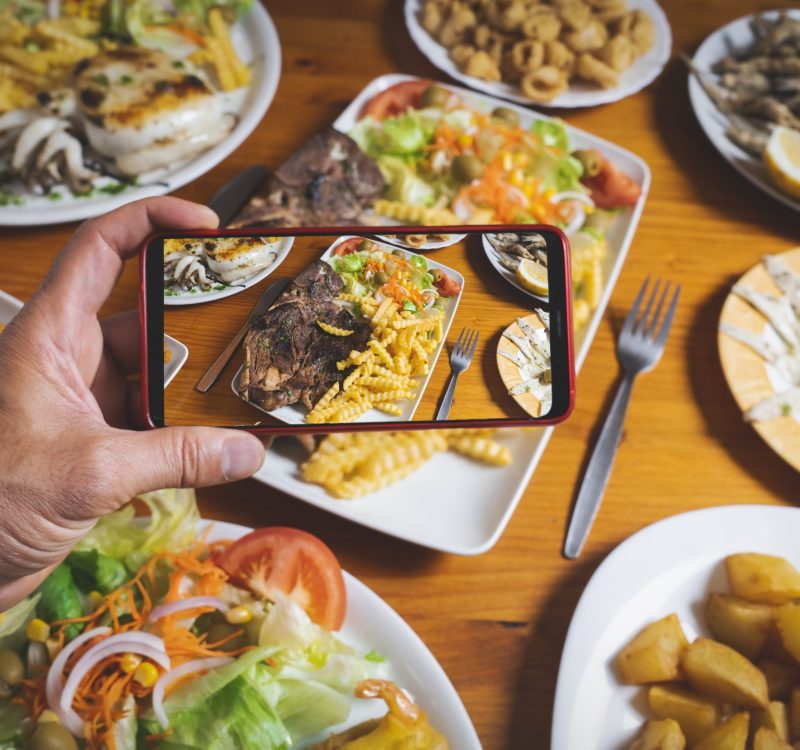 Blogger takes a picture of the dishes on the restaurant table